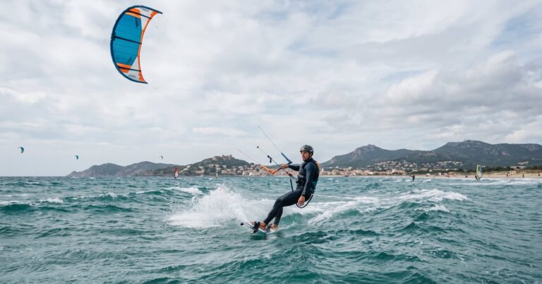 Kitesurfeur en action sur les eaux turquoise de Hyères, voile colorée déployée sous un ciel bleu